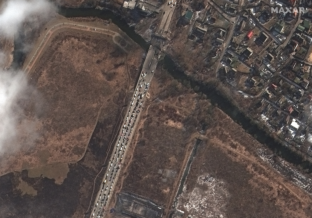 Refugiados aguardam para atravessar a ponte sobre o rio Irpin, destruída por bombardeios russos, em 10 de março.